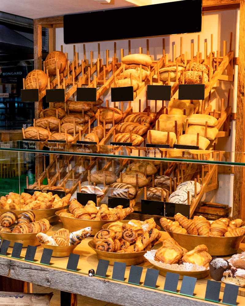Warmly lit shelves stacked with rustic loaves and rolls