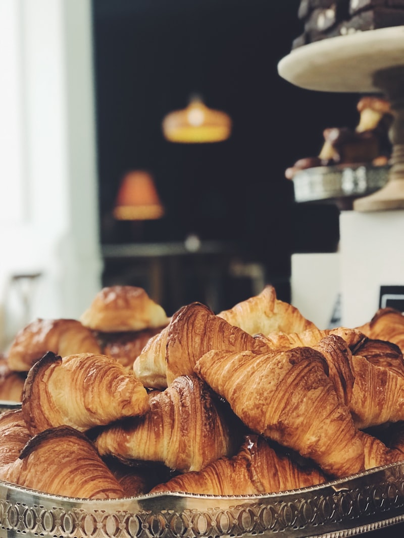 A basket of freshly baked croissants under warm bakery light