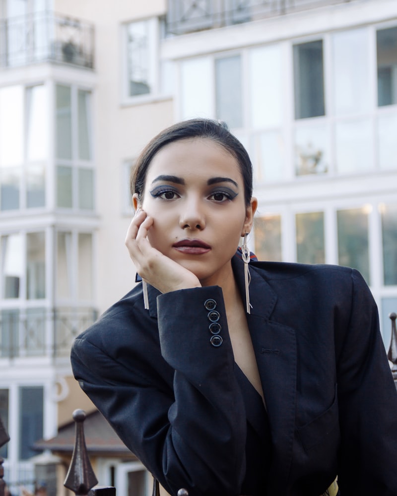 Model in a navy blazer resting against a wall