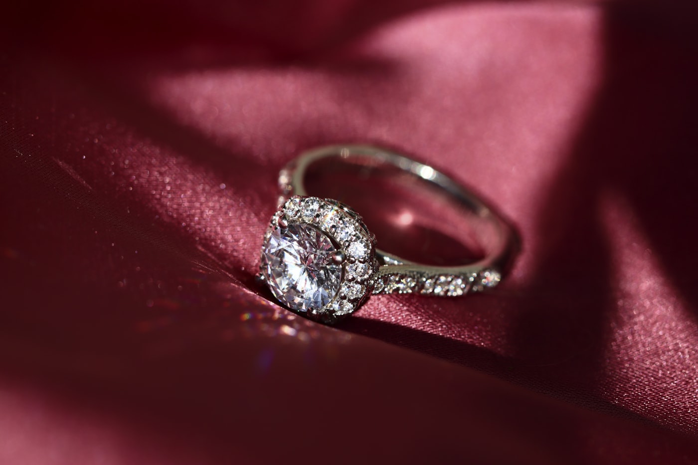 A diamond ring resting on deep red silk