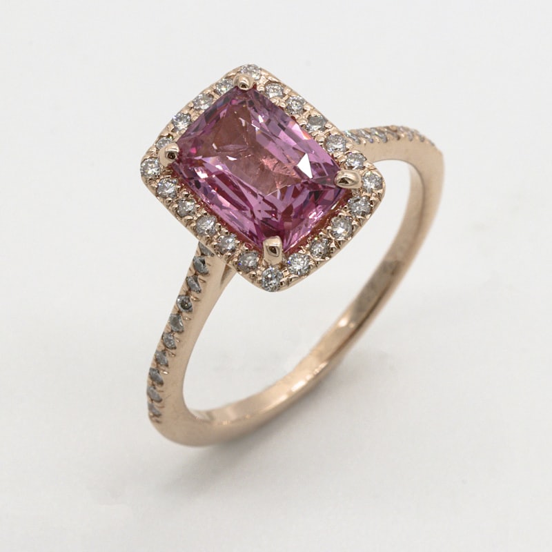 Pink sapphire ring set in rose gold with a diamond halo