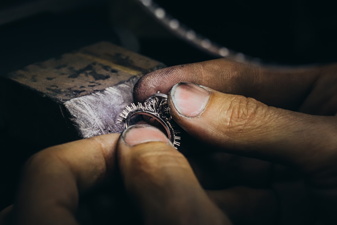 A master jeweller setting a stone by hand at the atelier bench