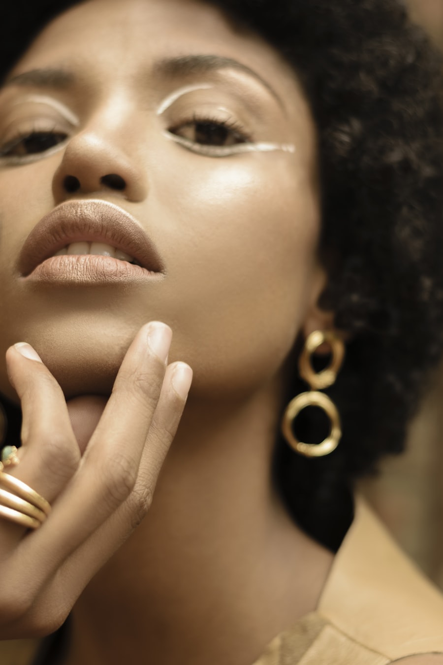 Model wearing a sculptural gold hoop earring