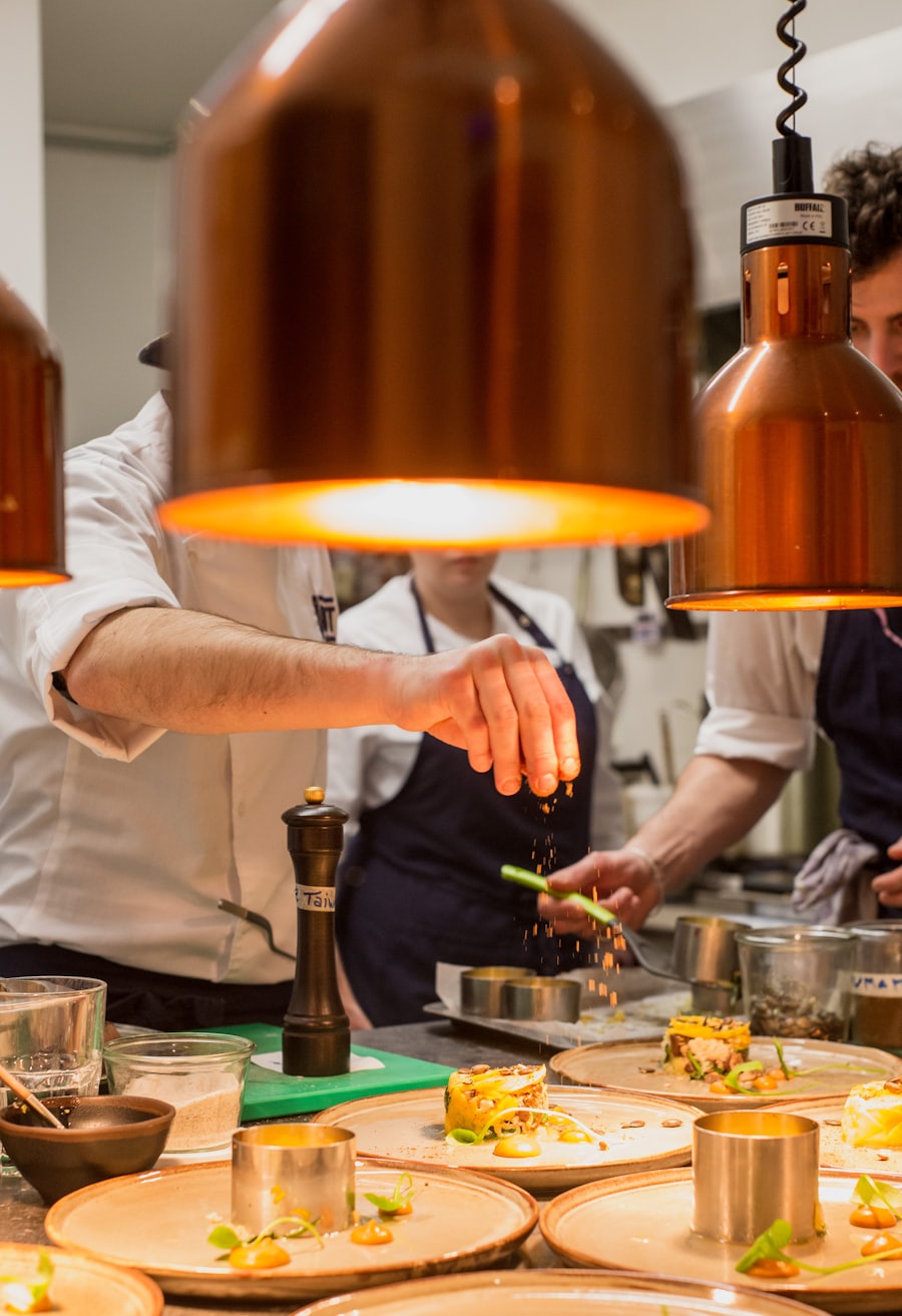 Chefs plating dishes under warm copper light in the NOIR kitchen
