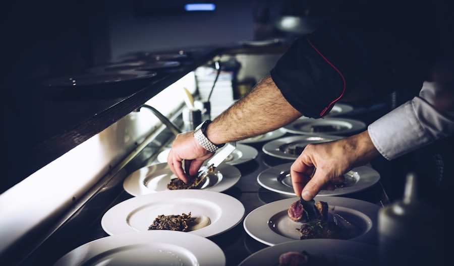Chefs plating at the pass under dramatic light