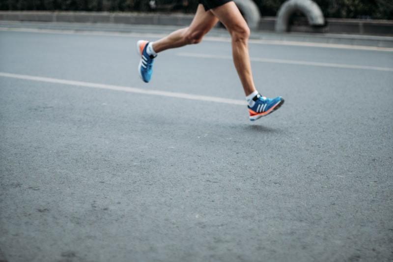 Runner mid-stride on an open road in VOLTA shoes
