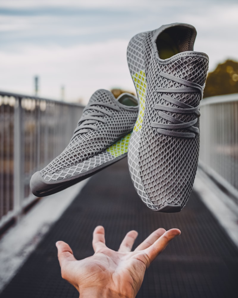 Grey knit VOLTA sneakers tossed in the air