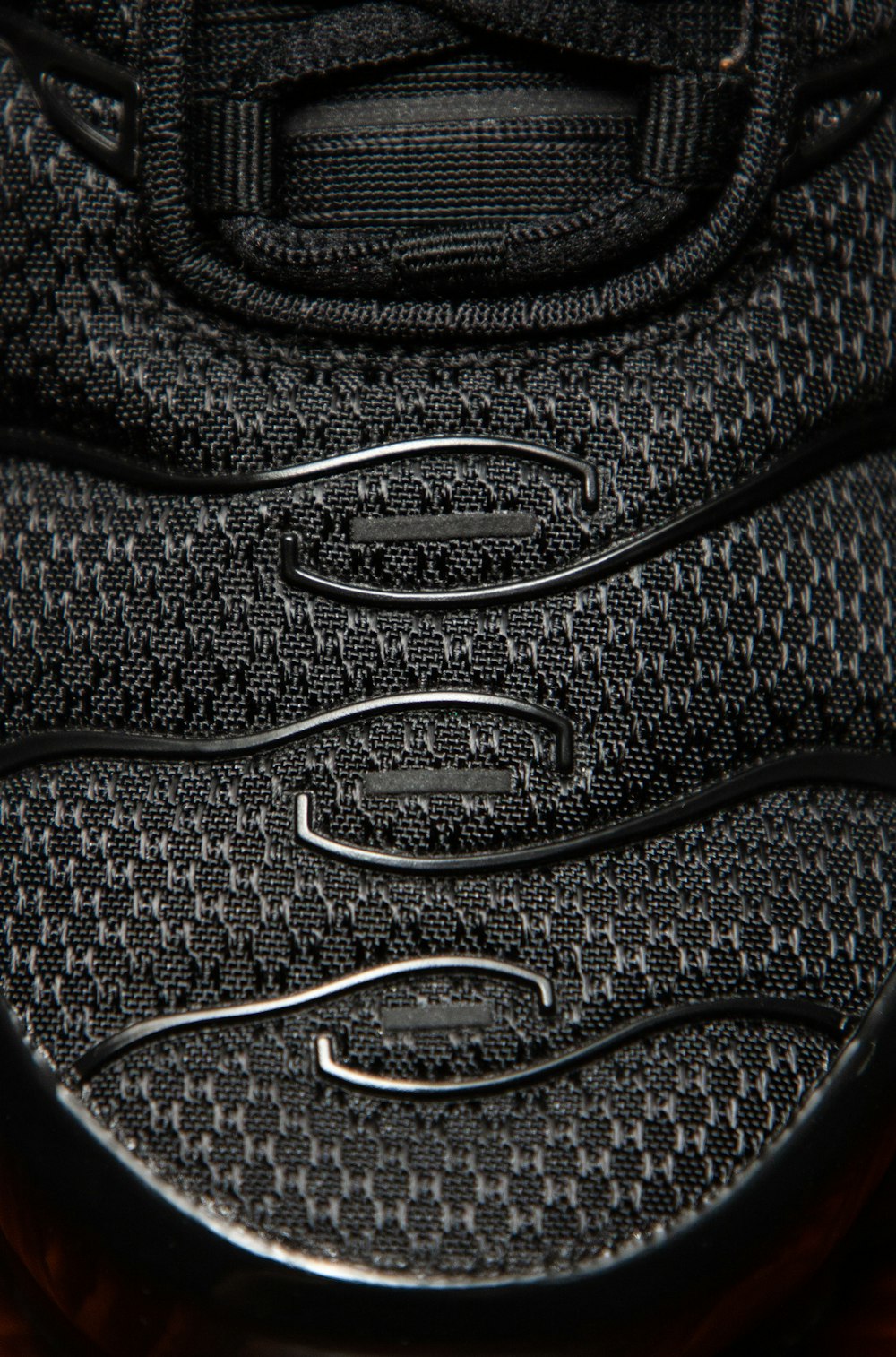 Extreme close-up of a black sneaker outsole tread pattern